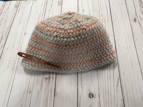 Beanie style hat in pink and grey made with nalbinding technique